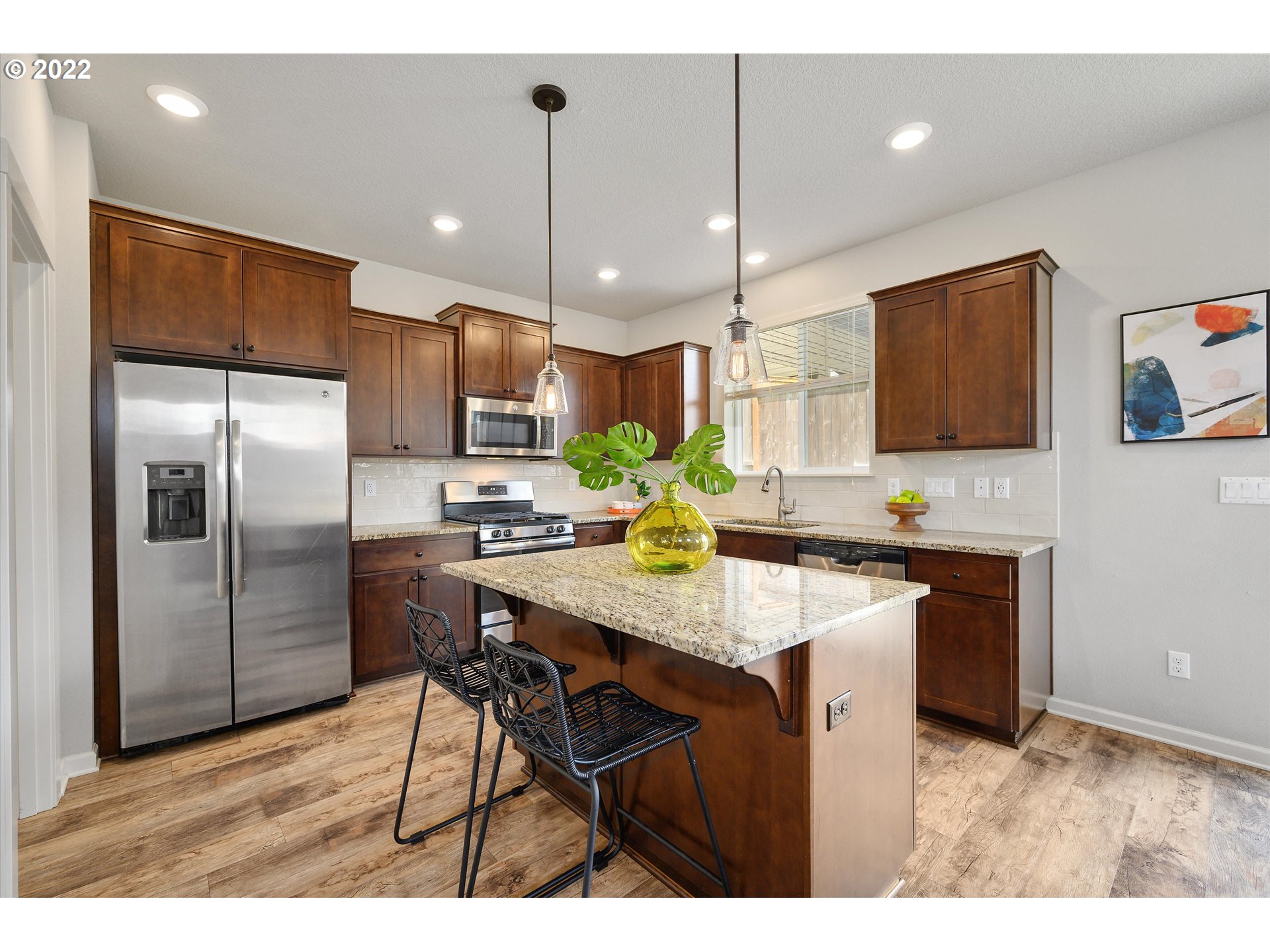 4288 Southwest Redfern Avenue Gresham, OR 97080 - Photo 8 of 32 a kitchen with stainless steel appliances kitchen island granite countertop a sink refrigerator and microwave