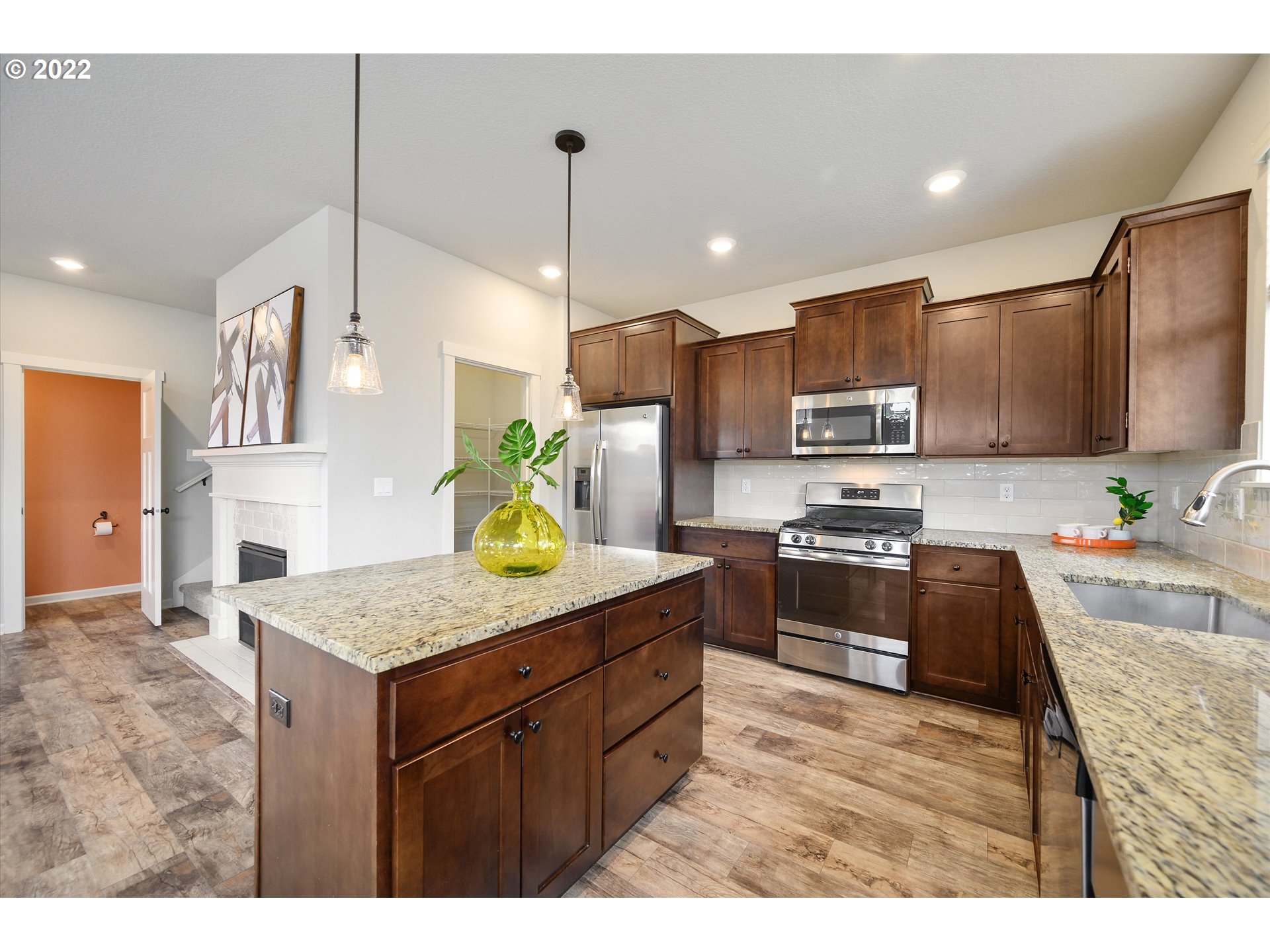 4288 Southwest Redfern Avenue Gresham, OR 97080 - Photo 9 of 32 a kitchen with stainless steel appliances kitchen island granite countertop a sink a stove top oven a granite counter space and cabinets