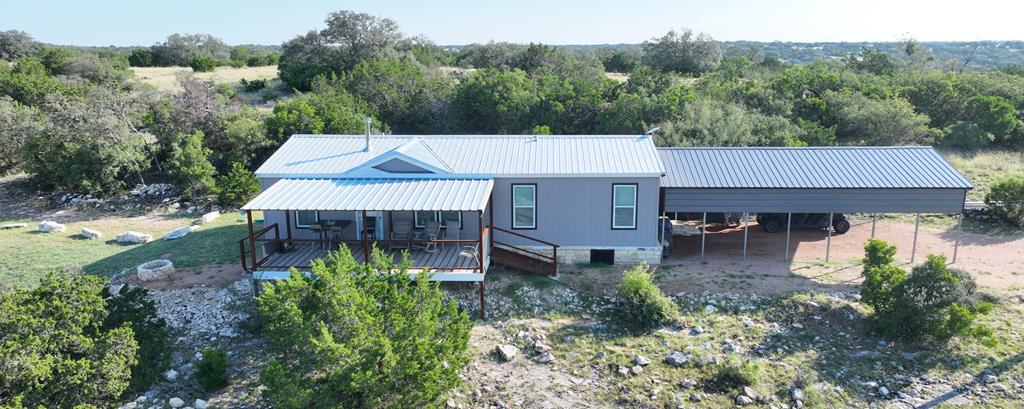 an aerial view of a house with yard and mountain view in back