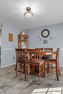 a dining room with a wooden table and chairs