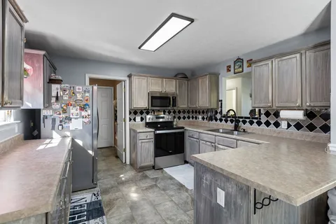 a kitchen with stainless steel appliances granite countertop a stove refrigerator sink and cabinets