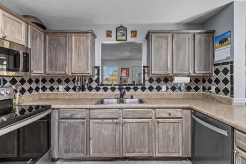 a kitchen with stainless steel appliances granite countertop a sink and a stove