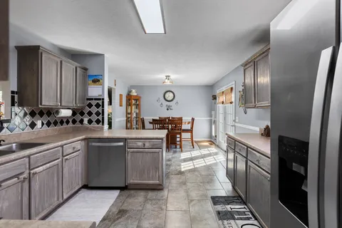 a kitchen with cabinets and chairs