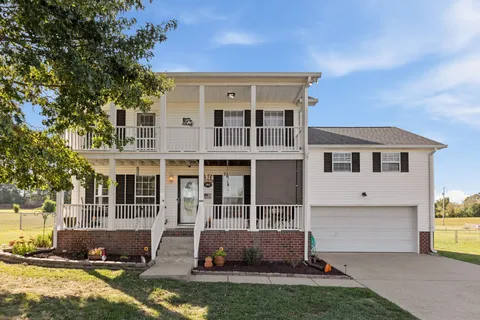 a view of house with yard and front view of a house