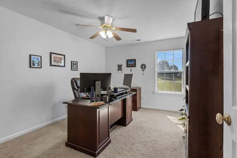 a view of a workspace with furniture and a window