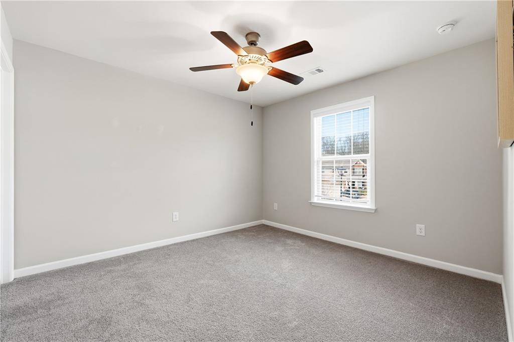 4735 Shiloh Valley Road Cumming, GA 30040 - Photo 22 of 39 an empty room with ceiling fan and windows