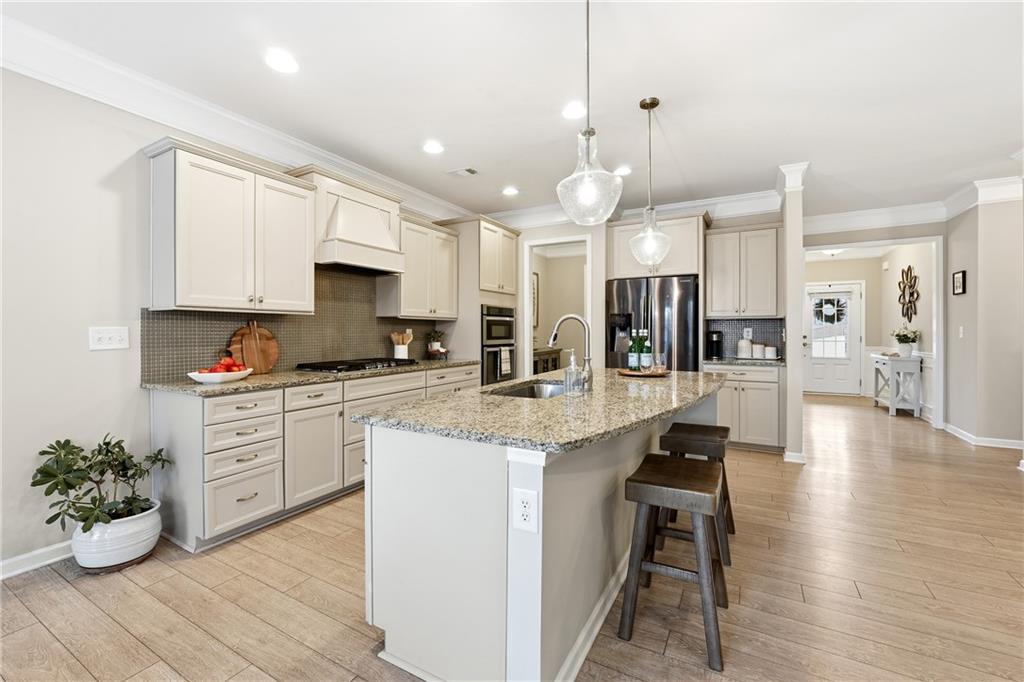 4735 Shiloh Valley Road Cumming, GA 30040 - Photo 7 of 39 a kitchen with stainless steel appliances kitchen island granite countertop a stove a sink and a refrigerator