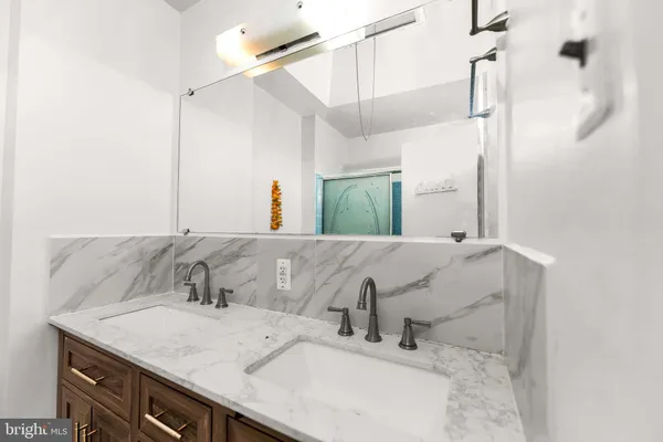 a bathroom with a granite countertop sink and a mirror