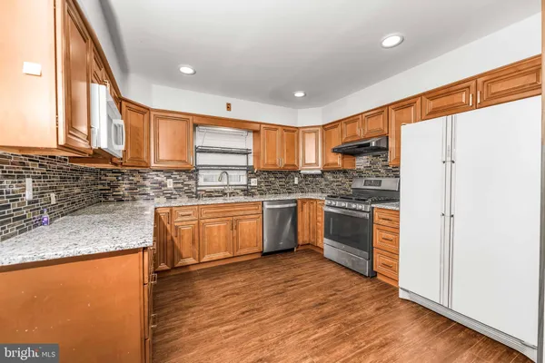 a kitchen with stainless steel appliances granite countertop a stove a sink and a refrigerator