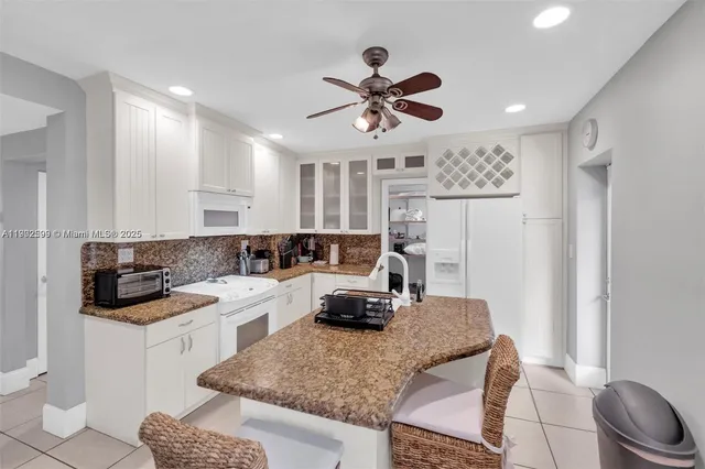 a kitchen with a sink a stove a refrigerator and white cabinets