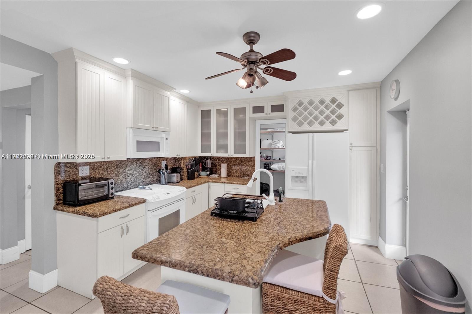 1033 Northwest 6 Street, Unit A Miami, FL 33136 - Photo 17 of 35 a kitchen with a sink a stove a refrigerator and white cabinets