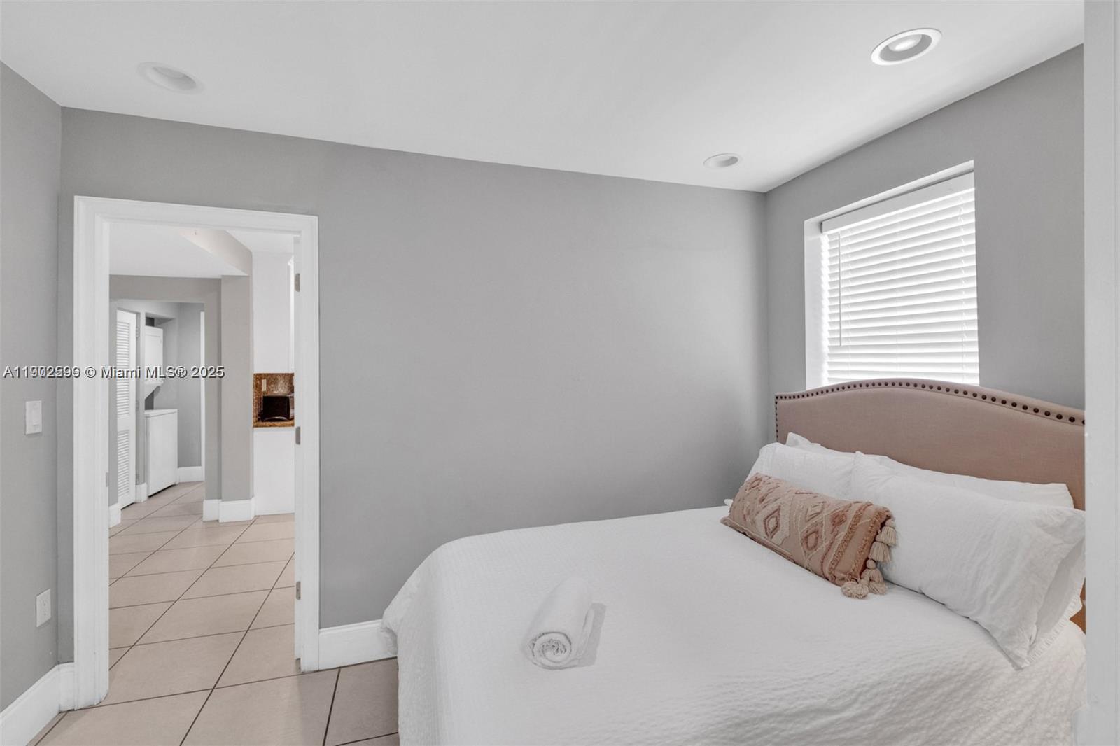 1033 Northwest 6 Street, Unit A Miami, FL 33136 - Photo 22 of 35 a bedroom with a bed and a mirror