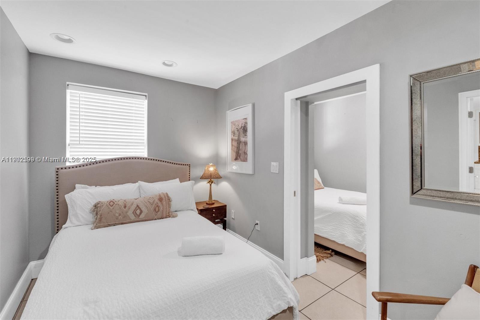 1033 Northwest 6 Street, Unit A Miami, FL 33136 - Photo 24 of 35 a bedroom with a bed and a mirror