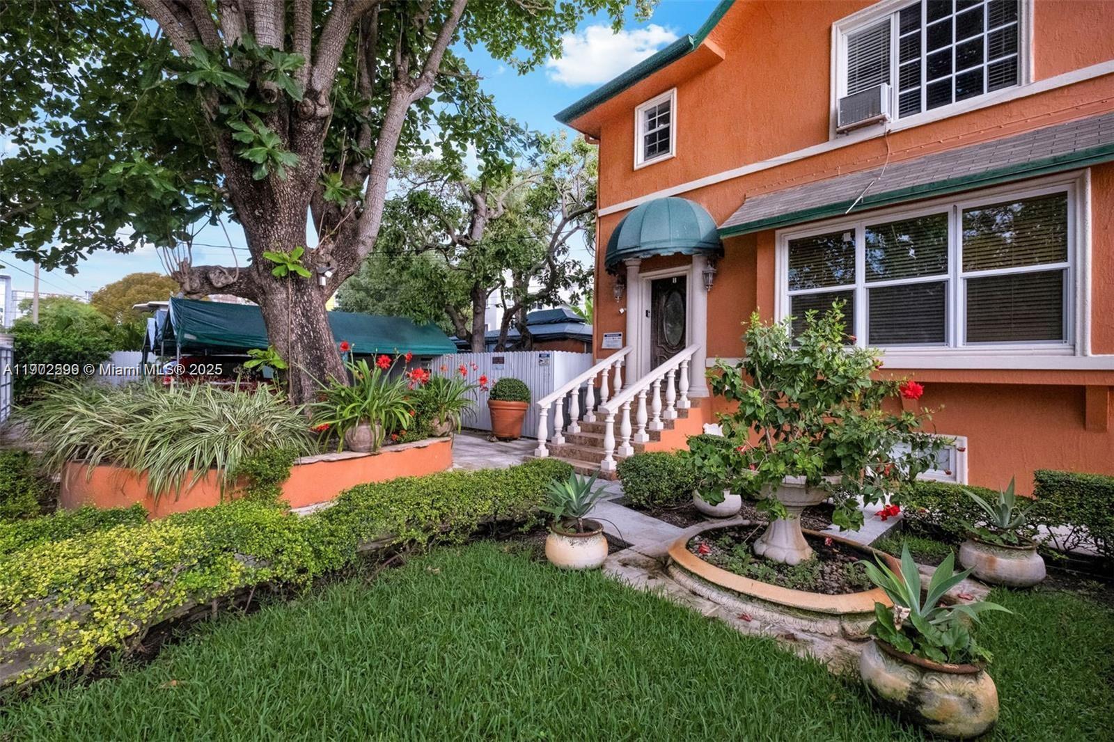 1033 Northwest 6 Street, Unit A Miami, FL 33136 - Photo 3 of 35 a front view of a house with a yard and potted plants
