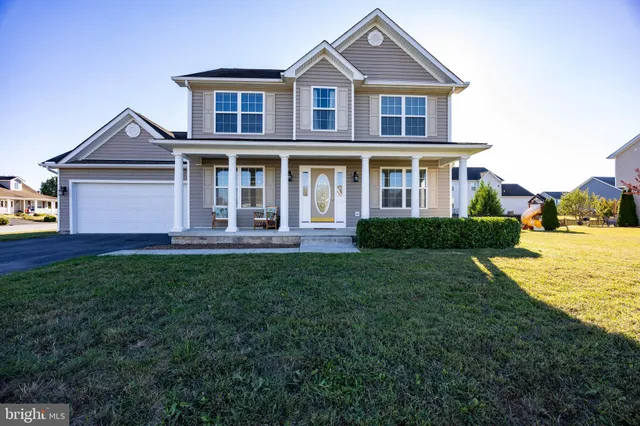a front view of a house with yard and green space