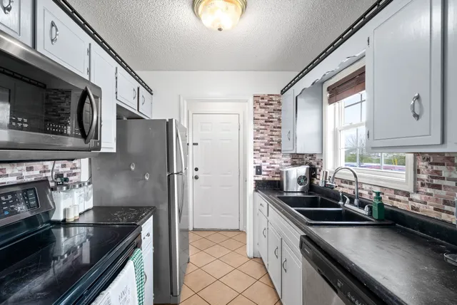 a kitchen with a sink stove top oven and cabinets