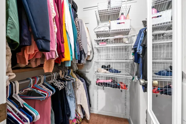 a view of walk in closet with clothes and shoes