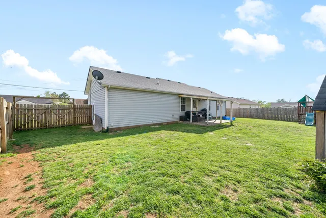 a backyard of a house with table and chairs