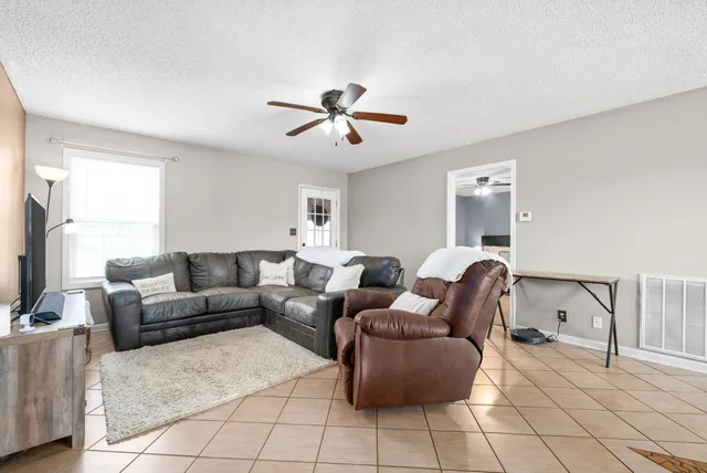 a living room with furniture and a ceiling fan