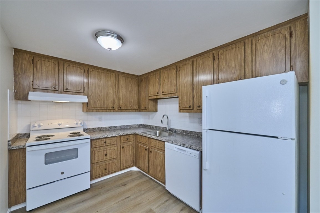 15 Old Colony Lane, Unit 7 Arlington, MA 02476 - Photo 1 of 12 a kitchen with a refrigerator sink stove and cabinets