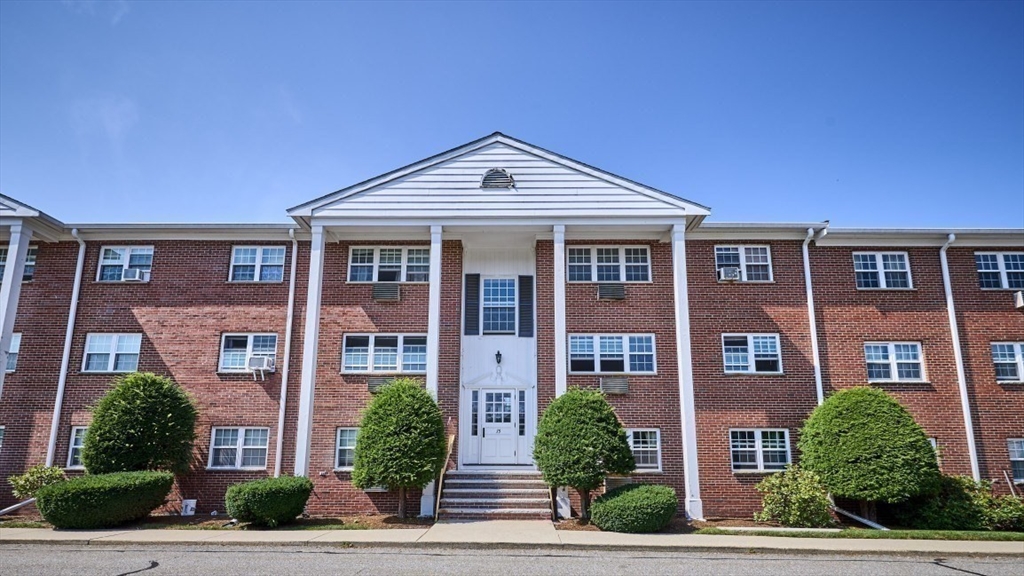 15 Old Colony Lane, Unit 7 Arlington, MA 02476 - Photo 12 of 12 a front view of a residential apartment building with a yard