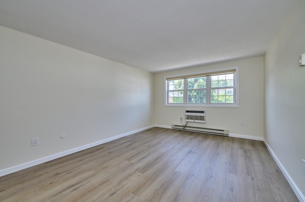 15 Old Colony Lane, Unit 7 Arlington, MA 02476 - Photo 4 of 12 an empty room with wooden floor and windows