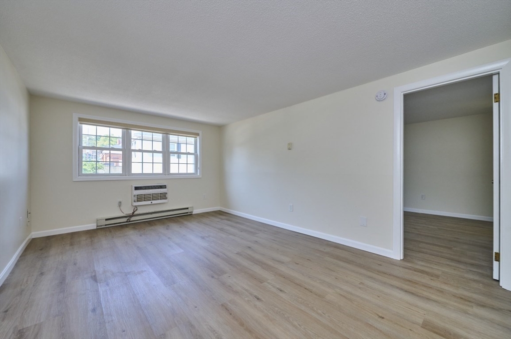 15 Old Colony Lane, Unit 7 Arlington, MA 02476 - Photo 5 of 12 an empty room with wooden floor and windows