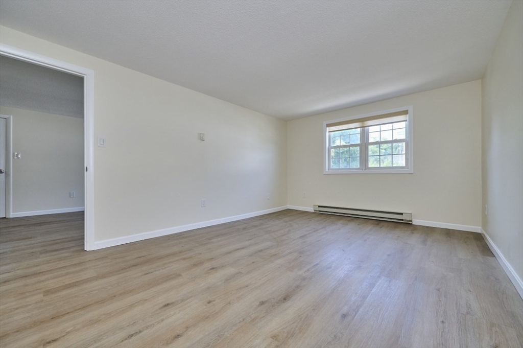 15 Old Colony Lane, Unit 7 Arlington, MA 02476 - Photo 7 of 12 an empty room with wooden floor and windows