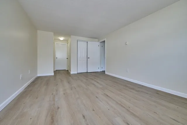 a view of empty room with wooden floor