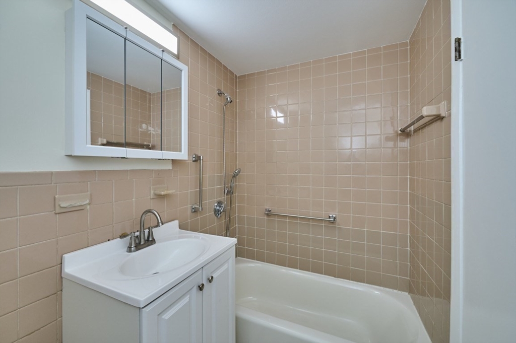 15 Old Colony Lane, Unit 7 Arlington, MA 02476 - Photo 9 of 12 a bathroom with a sink a toilet and shower