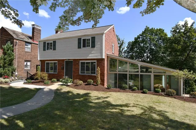 a front view of a house with garden and patio