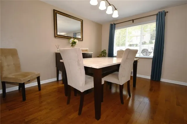a kitchen with stainless steel appliances granite countertop table chairs sink and cabinets