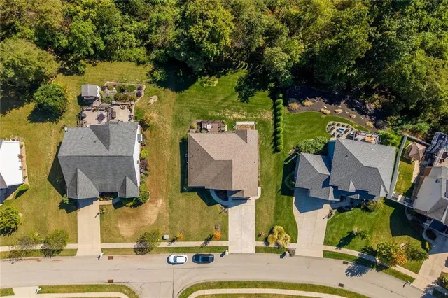 an aerial view of residential houses with outdoor space and parking