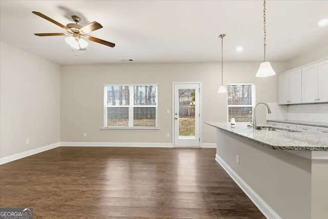 a view of an empty room with window and wooden floor