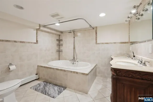 a bathroom with a sink a toilet a mirror and shower