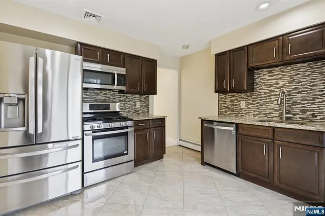 a kitchen with granite countertop stainless steel appliances and sink