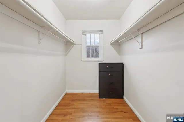 a view of a hallway with wooden floor and a window