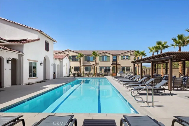 a view of a house with pool and chairs