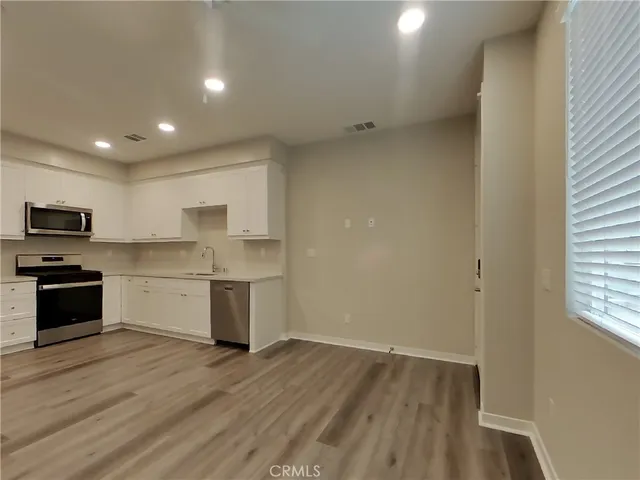 a kitchen with a refrigerator and a stove top oven