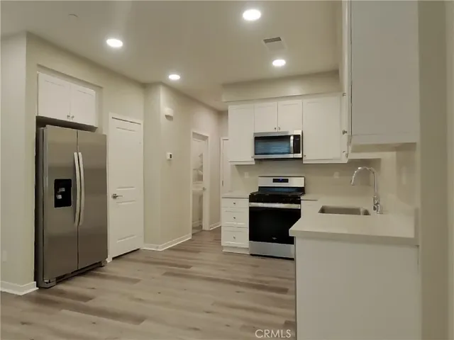 a kitchen with stainless steel appliances granite countertop a stove a refrigerator and a microwave