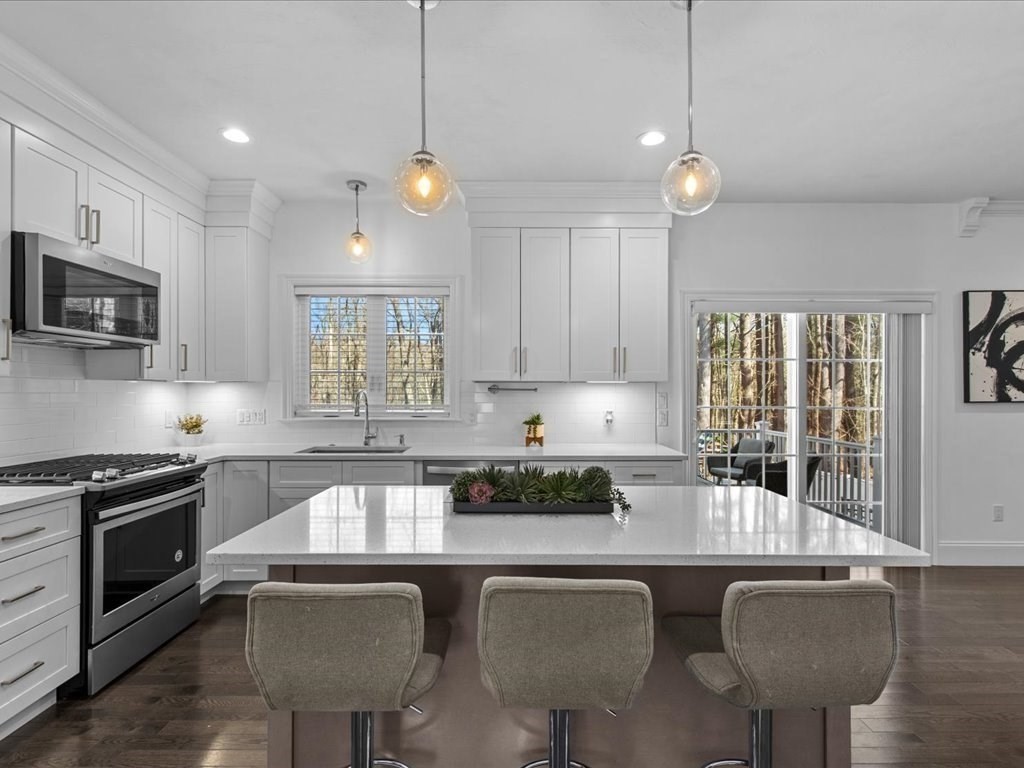 5 Greenbriar Lane Bellingham, MA 02019 - Photo 9 of 26 a kitchen with stainless steel appliances granite countertop a stove top oven a sink a dining table and chairs