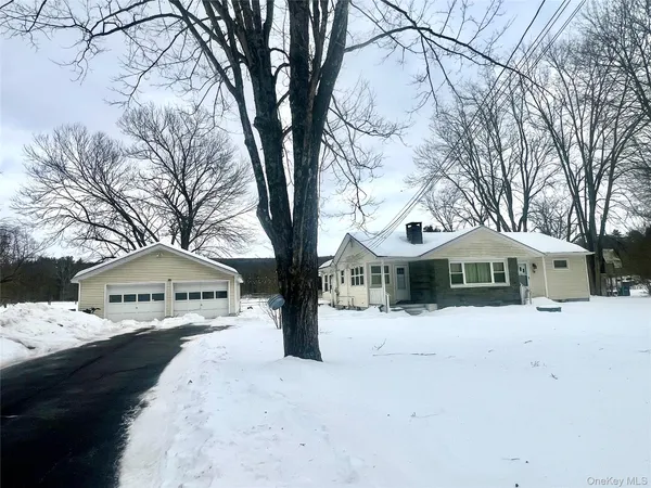 a front view of a house with a yard covered in snow