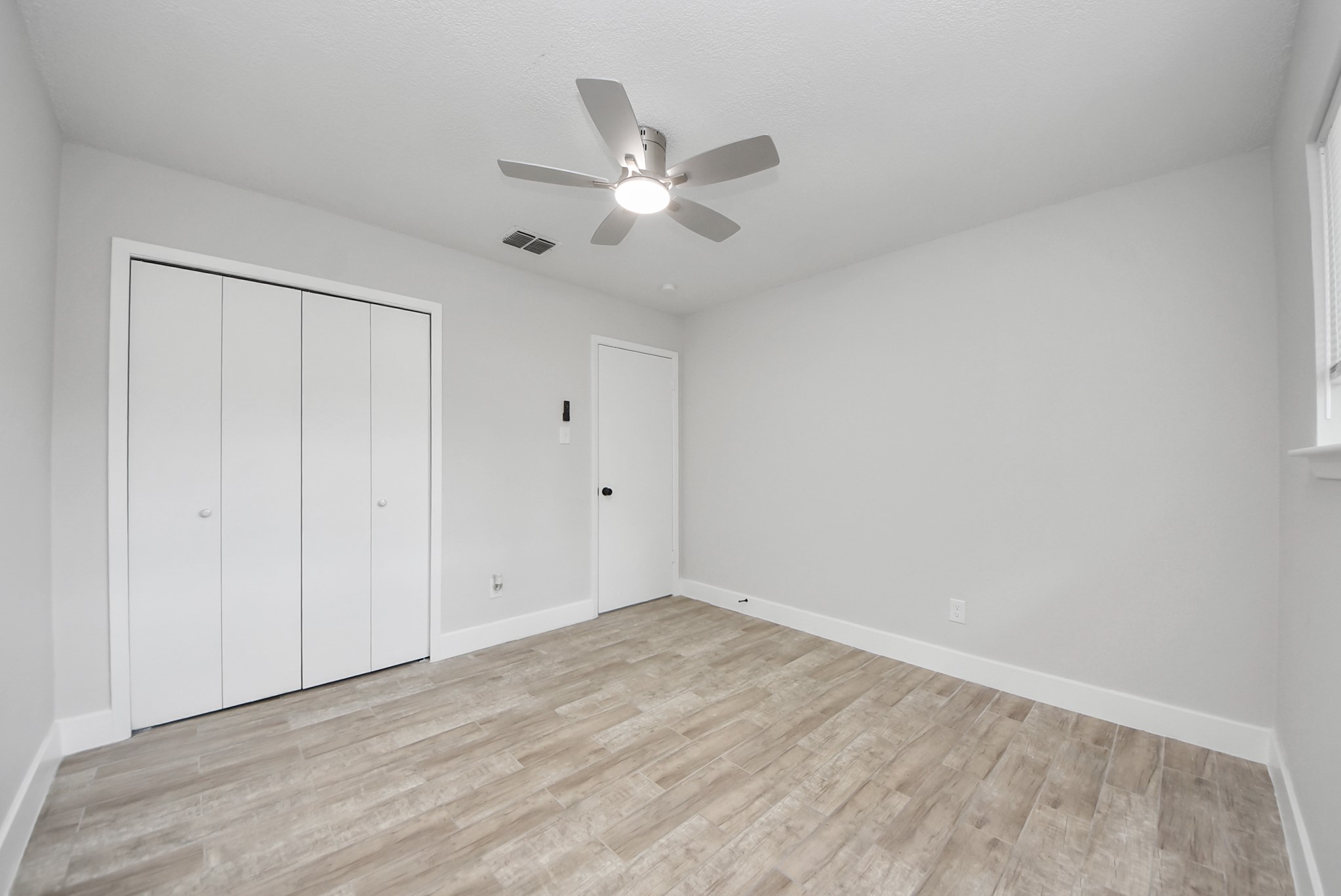 5314 Sweetwind Lane Spring, TX 77373 - Photo 36 of 47 Bedroom on the left with sleek floors, a modern ceiling fan, and a spacious closet, perfect for comfort and organization.