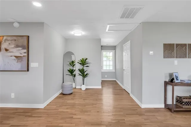 a view of a hallway to room with wooden floor
