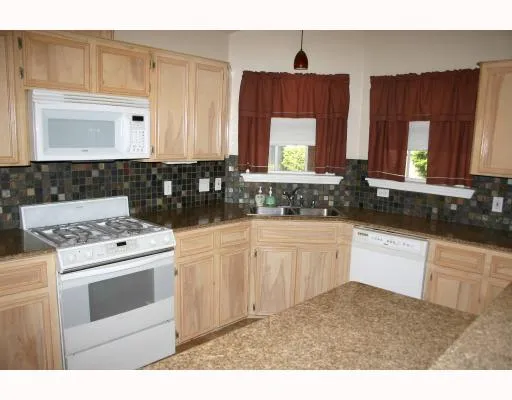 a kitchen with cabinets appliances a sink and a window
