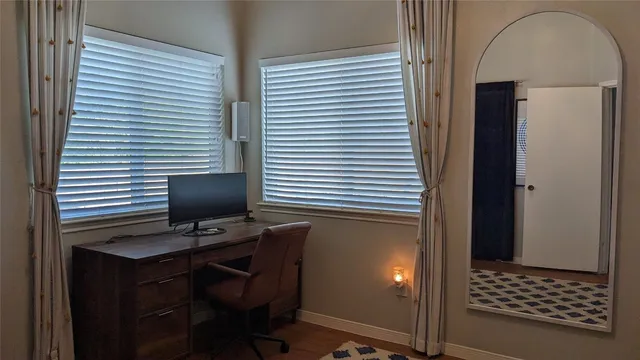 a view of a workspace with furniture and a window