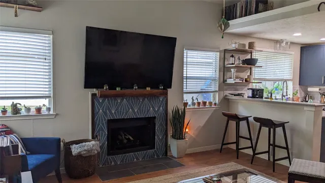 a living room with furniture a flat screen tv and a fireplace