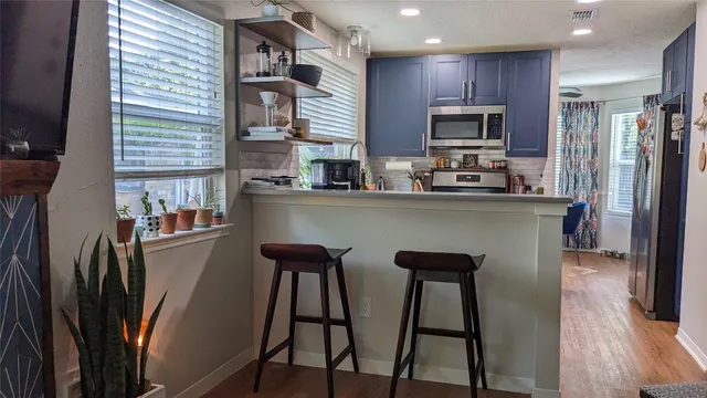 a kitchen with stainless steel appliances granite countertop a refrigerator a stove top oven a sink dishwasher and wooden cabinets