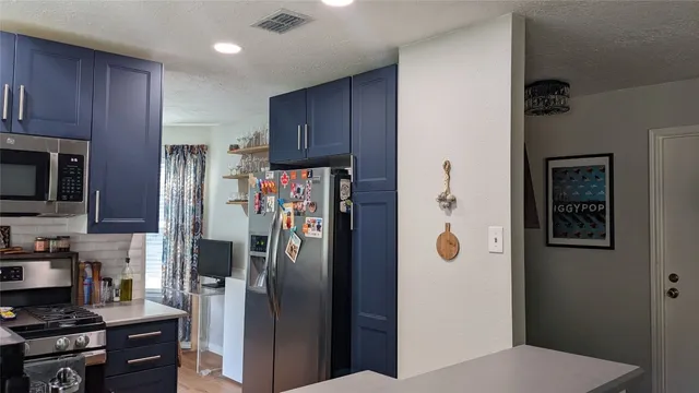 a kitchen with stainless steel appliances granite countertop a refrigerator and a stove top oven