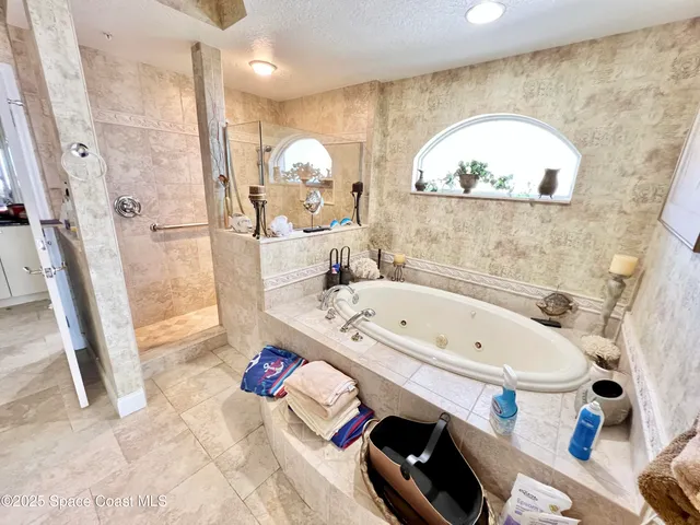 a bathroom with a tub a sink and a mirror